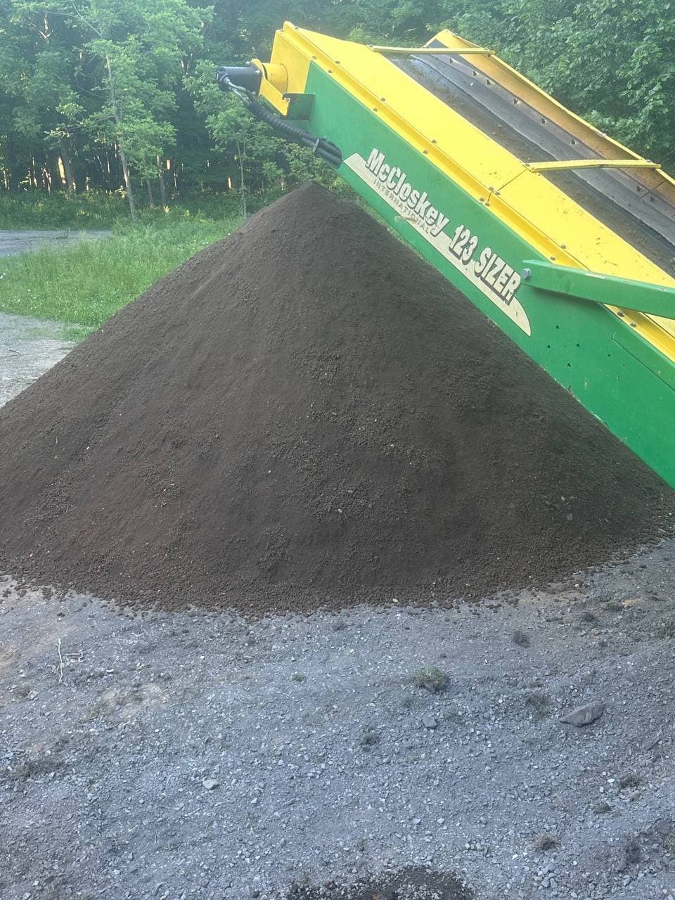 McCloskey 123 Sizer screening a fresh cone of dark screened topsoil