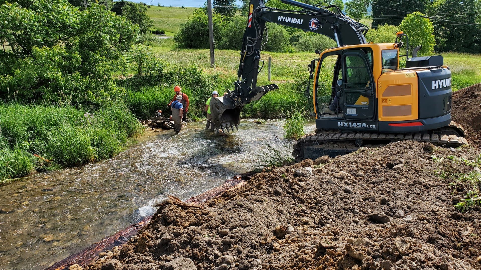 Hyundai HX145A excavator working in the stream during bank rebuild