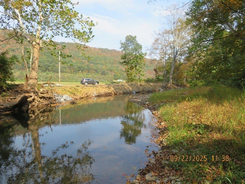 Restored mountain creek with a truck in the distance in fall colors
